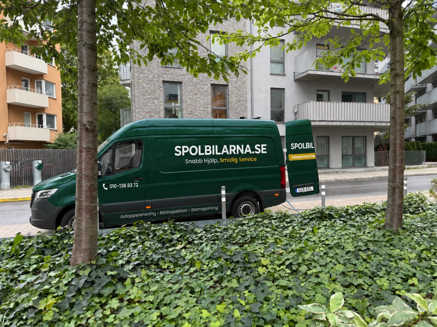 Spolbil från Spolbilarna parkerad på gatan utanför ett flerbostadshus – Spolbilarna i Karlshamn